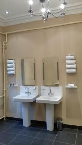 two sinks in a bathroom with mirrors and towels at Tor-Na-Coille Hotel in Banchory