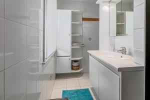 a white bathroom with a sink and a shower at Juliette V4 P in Oostduinkerke