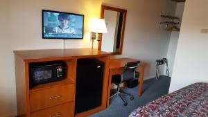 a hotel room with a television and a desk with a bed at Travelers Lodge Marshall in Marshall