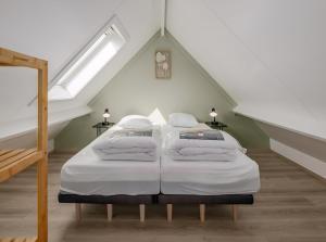 a bedroom with two beds in a attic at Tzeehuisje 57P in Oostduinkerke