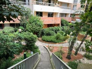 ogród z drzewami i krzakami przed budynkiem w obiekcie Cosy Duplex avec Parking à Paris 19 by immo kit bnb w Paryżu