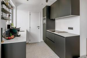 东代恩凯尔克Kenydou 0101G的厨房配有黑白橱柜和门