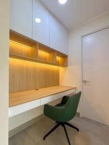 a green chair sitting in front of a desk at Alta Apartments by Geko in Lima