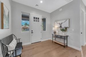 Sala de estar blanca con mesa y puerta en Luxury Mountain Retreat with studio apartment, en Williams