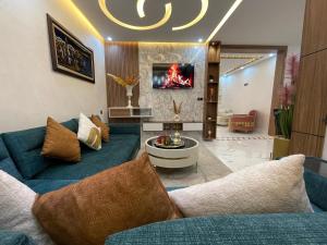 a living room with a blue couch and a tv at Modern Apartment Airport in Marrakesh