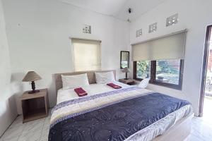 Un dormitorio con una cama grande y una ventana. en Carla Garden, en Yogyakarta