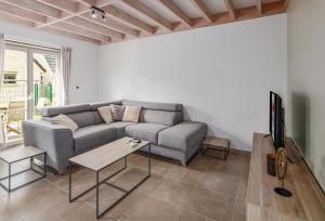 a living room with a couch and a tv at Tzeehuisje 57P in Oostduinkerke