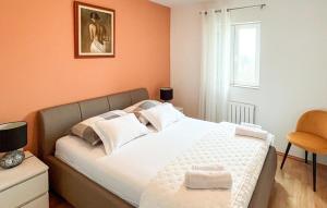 a bedroom with a large white bed with orange walls at Stunning Apartment In Supetar With Wifi in Supetar