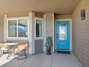 eine Veranda mit einer blauen Tür sowie einem Tisch und Stühlen in der Unterkunft Pickleball at 7000ft Private home with Court in Elden Pueblo