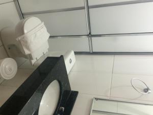 a bathroom with a white toilet and a mirror at Hotel Castro Mendes in Campinas