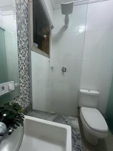 a white bathroom with a toilet and a sink at Casa Caborê, Paraty-RJ in Paraty +14 photos