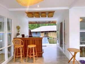 a kitchen with a bar with two stools at ลอยภิรมย์ Loypirom in Ban Huai Sai