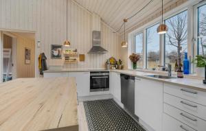 Una cocina con gabinetes blancos y una encimera de madera. en Beautiful Home In Fårevejle With Wifi, en Fårevejle