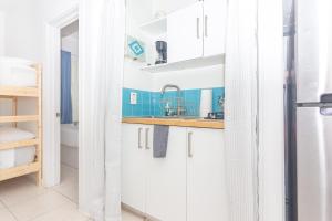 a kitchen with white cabinets and a sink at Ocean Villa in Miami Beach +21 photos