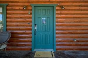 eine grüne Tür an der Seite eines Hauses in der Unterkunft Spacious Cozy Cabin Retreat on 5-Acres with HotTub in Elden Pueblo