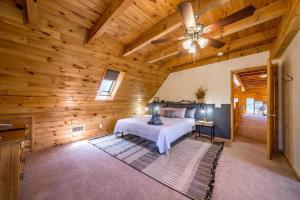 ein Schlafzimmer mit einem Bett und einer Holzdecke in der Unterkunft Spacious Cozy Cabin Retreat on 5-Acres with HotTub in Elden Pueblo
