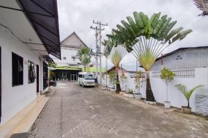 een straat met palmbomen en een vrachtwagen geparkeerd op straat bij RedDoorz near Focal Point Medan in Sunggal +31 foto's