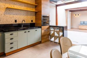 a kitchen with a sink and a table with chairs at Casa Ampla 5 min da Lagoa da Pampulha in Contagem