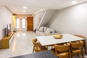 a living room with a table and a couch at Casa Ampla 5 min da Lagoa da Pampulha in Contagem