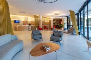 a lobby with couches and chairs and a table at LFlats no Hotel Aeroporto Congonhas in Sao Paulo