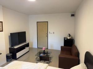 a living room with a couch and a television at Natthapimon in Bangkok Yai +4 photos