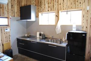 三豊市にある一軒宿 百々 private house rental doudouのキッチン(シンク、黒い冷蔵庫付)