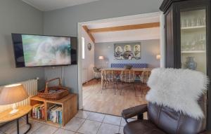 a living room with a table and a television at Stunning Home In Wemeldinge With Sauna in Wemeldinge