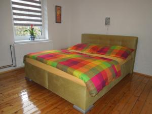 Bett mit farbenfroher Bettdecke in einem Zimmer in der Unterkunft Apartments Benešov Nad Ploučnicí in Benešov nad Ploučnicí