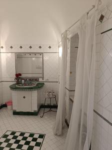 a white bathroom with a sink and a mirror at Love in Blue - La Terrazza di Positano in Positano