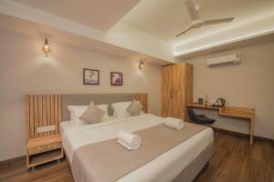 门格洛尔Hotel Shoolin Comforts的一间卧室配有一张大床和吊扇