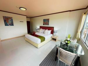 a hotel room with a bed and a table and a bed at Thipurai Beach Hotel in Hua Hin