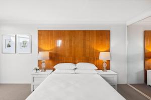 悉尼Spacious Inner-West 2-Bed with Alfresco Dining的卧室配有一张白色大床和两盏灯。 更多8张照片