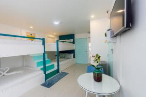 a room with two bunk beds and a table at Indila Boracay in Boracay