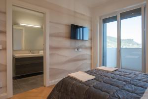 a bedroom with a bed and a sink and a mirror at Porta del Mare - Luxury Beachfront Apartments in Salerno