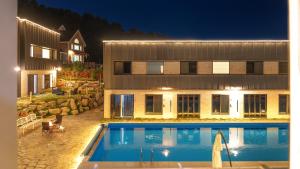 a swimming pool in front of a house at night at Gapyeong Orion PoolVilla pension in Gapyeong +20 photos