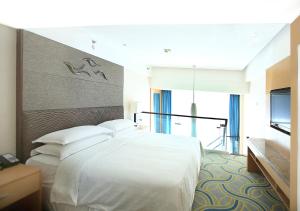 Postel nebo postele na pokoji v ubytování Sheraton Yantai Golden Beach Resort