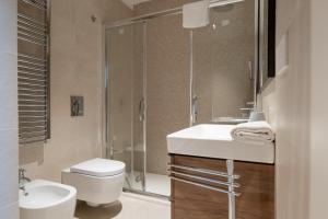 a bathroom with a toilet and a sink and a shower at Porta del Mare - Luxury Beachfront Apartments in Salerno +37 photos