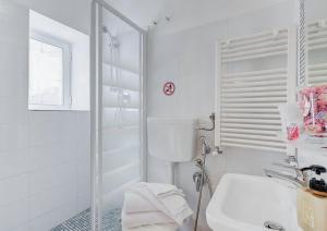 uma casa de banho branca com um lavatório e um chuveiro em Machiavelli Suites em Roma