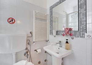uma casa de banho branca com um lavatório e um espelho em Machiavelli Suites em Roma