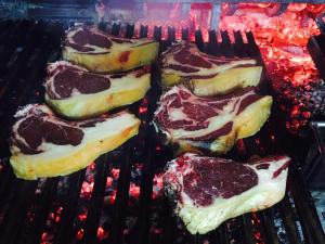 a group of food cooking on a grill at Hotel Parrilla el Zangano in Boal