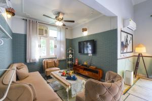 a living room with a couch and a tv at Alaya Stays Anugrah Farm - 2 BHK Farmstay With Kids Room & Pvt Pool in Bahora