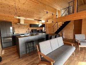 a kitchen and living room with a counter and a table at ホースリトリート八ヶ岳 in Hokuto