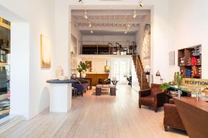 een woonkamer met een bank, stoelen en een tafel bij Hotel Palazzo Guiscardo in Pietrasanta