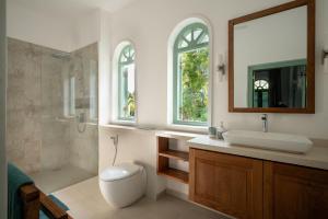 a bathroom with a toilet and a sink and a shower at Kalkudah Beach House in Batticaloa +39 photos