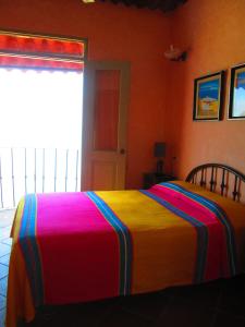 a bed with a colorful blanket on it in a room at Hotel Vereda Tropical in Taboga