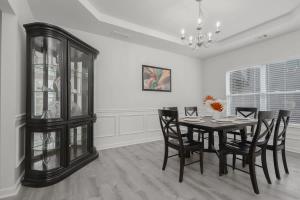 a dining room with a table and chairs and a chandelier at Large Rustic Family Home By RoadATL-KingBed-Firepit-Grill in Braselton