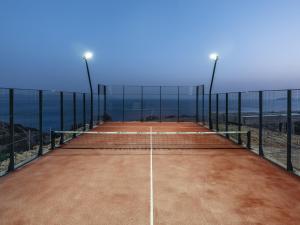 a tennis court on the beach with the ocean in the background at Keras Cliff House in Agia Galini