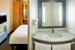 ein Badezimmer mit Waschbecken und Spiegel in der Unterkunft ibis Macae in Macaé