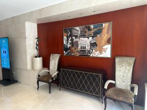 a lobby with two chairs and a picture on the wall at Baolong Hotel Shanghai in Shanghai