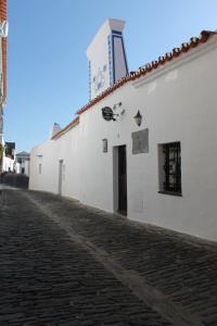 un edificio blanco con una torre de reloj encima en Casa Daterra en Monsaraz